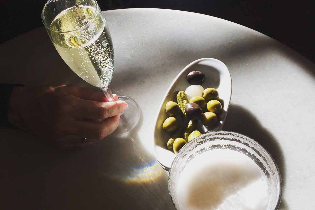 A glass of cava, a glass of beer and a bowl of olives in the afternoon Barcelona sun