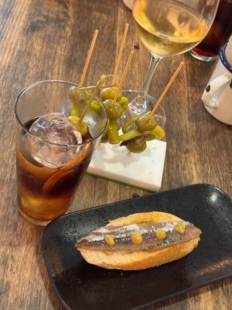 Smoked sardine on bread, Gildas, a glass of wine and a glass of vermouth at Celler Florida in Barcelona