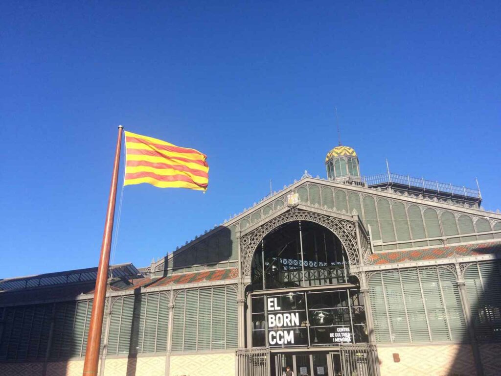 The Catalan flag flying in front of the steel facade of the Mercat del Born in Barcelona