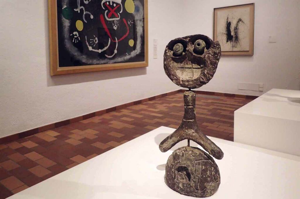 Statue in the foreground and paintings in the background at the Miro Foundation in Barcelona
