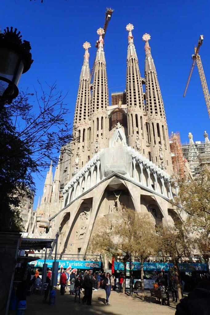 The facade of La Sagrada Familia in Barcelona with tourists in the foreground